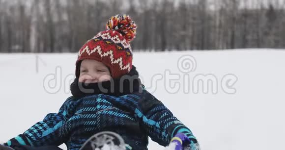 在雪地里玩雪橇的孩子视频的预览图