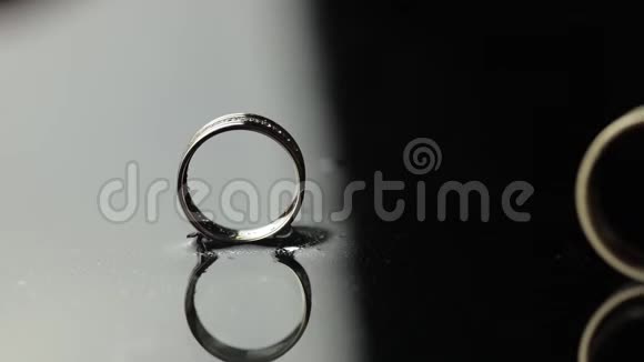 婚礼戒指在黑色白色的水面上新郎的戒指滚向新娘戒指视频的预览图
