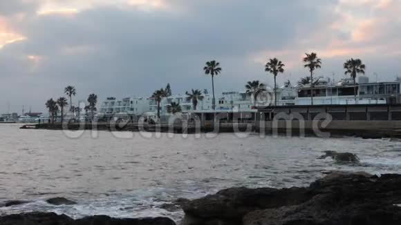 傍晚黄昏时分用棕榈树咖啡馆和餐馆来清空旅游码头令人难以置信的日落与海滨太阳挣扎着打破视频的预览图