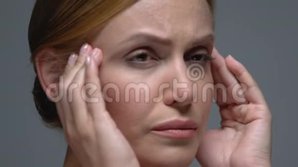 不高兴的女人按摩疼痛的太阳穴头痛偏头痛视频的预览图