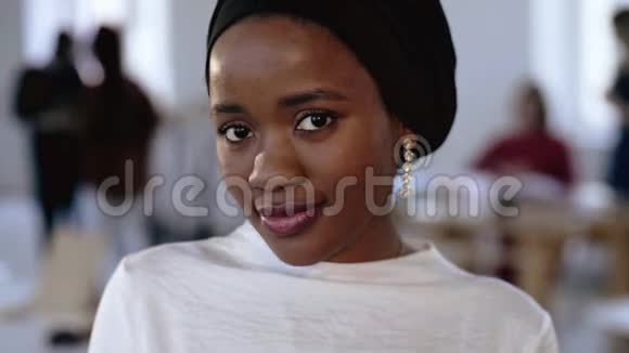年轻快乐的非洲商务女性的特写肖像在少数民族的头巾摆姿势微笑在现代时尚的办公室视频的预览图