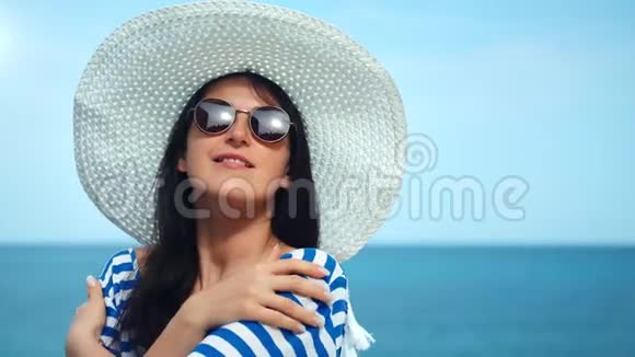 中等特写肖像美女旅行戴着白帽子戴着太阳镜在海底摆姿势视频的预览图