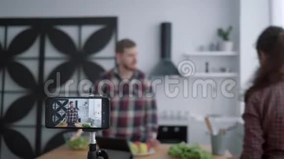 博客写手们在手机拍照的同时用蔬菜和蔬菜准备健康食品视频的预览图