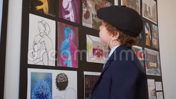 小男孩在美术馆看照片小男孩在创意画廊里看艺术照片现代绘画艺术视频的预览图