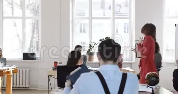 幸福微笑的中年白种人商务女性走在现代多民族的办公室同事们为她鼓掌视频的预览图