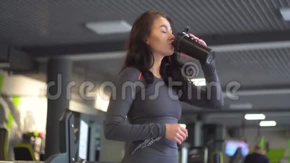 漂亮的女孩在健身房里喝淡水视频的预览图