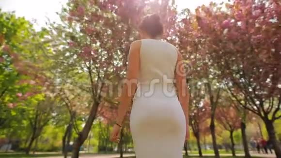 快乐的女人站在夏天公园里乱扔头发视频的预览图