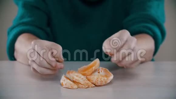 一个男人正把桌上一个成熟的橘子打碎视频的预览图
