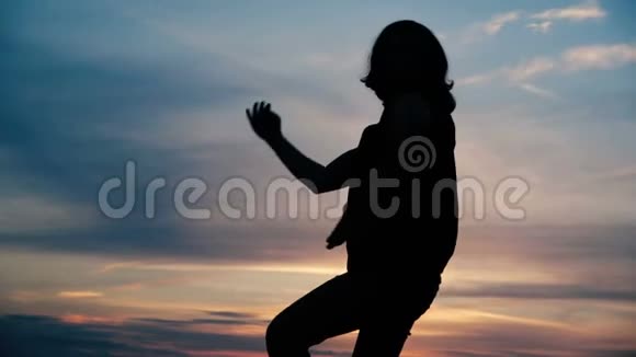 晚上在五彩缤纷的天空背景下跳舞的男人慢动作视频的预览图