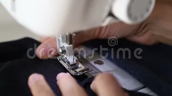 女士在缝纫机上缝制织物缝纫机上妇女手和织物的特写视频的预览图