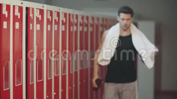疲惫的男人在锻炼后走进更衣室视频的预览图