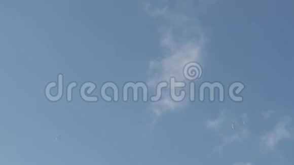 在风的引导下在浅蓝色的天空中漂浮着肥皂气球的慢镜头视频的预览图