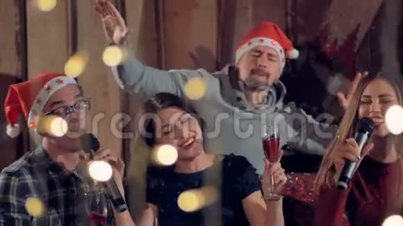 一群快乐的朋友在圣诞晚会上唱卡拉OK玩得很开心4K视频的预览图