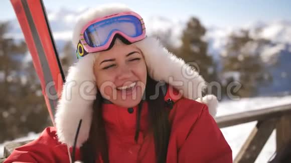 两个可爱的女孩滑雪者坐在山顶的咖啡馆里喝着覆盖的葡萄酒和有趣的谈话视频的预览图
