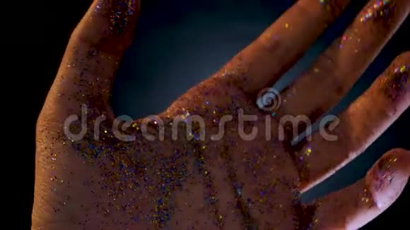 女性手上盖着亮片你的手掌的移动和发光的五彩闪光视频的预览图