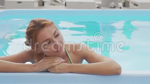 在室外游泳池放松的漂亮女人视频的预览图