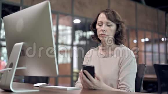 工作中使用智能手机的老妇人视频的预览图