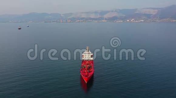 从上往下看红色超大号空货船在海上的空中镜头视频的预览图