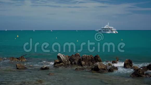 岩石海岸巨大的石头海岸的波浪和令人难以置信的绿松石蓝色的夏季海背景是白色游艇视频的预览图