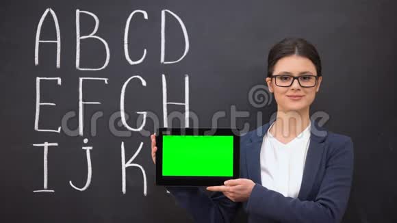 微笑老师拿着预先准备好的平板电脑黑板上的字母表创新视频的预览图