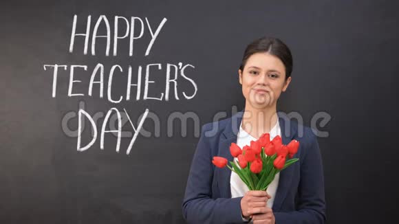 快乐的教师日写在黑板上微笑的女士和郁金香站在附近视频的预览图