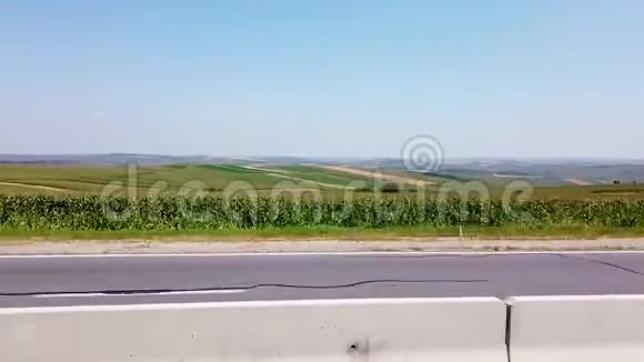 路高速公路路的另一边是绿色的田野夏天万里无云的一天从车窗看到视频的预览图