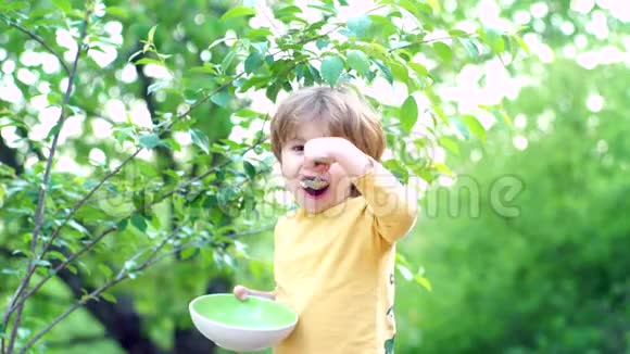 为孩子们提供食物和饮料小男孩在加顿吃早餐快乐的小男孩勺子在户外吃宝贝视频的预览图
