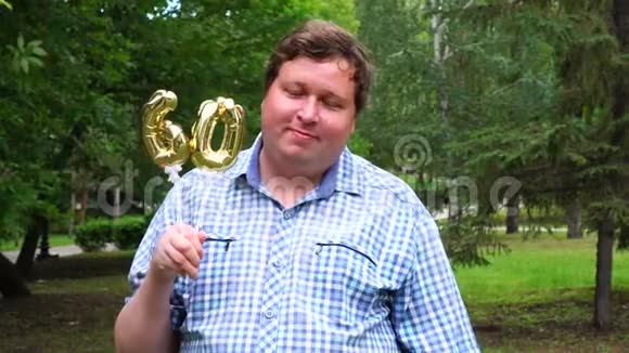 大个子拿着金色气球做60号户外60周年庆祝晚会视频的预览图
