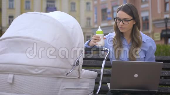 忙碌的办公室工作人员在手提电脑上挣扎在婴儿车上照顾婴儿视频的预览图