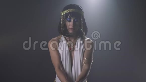 蓝妆的埃及艳后用双手倒沙动作缓慢视频的预览图