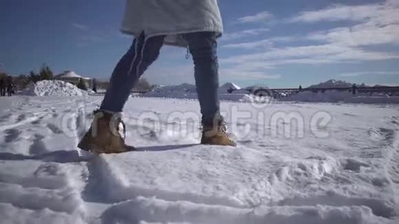 女人穿着米色靴子在雪地里行走视频的预览图