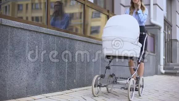 女士带着婴儿车在商务中心附近行走可多任务视频的预览图
