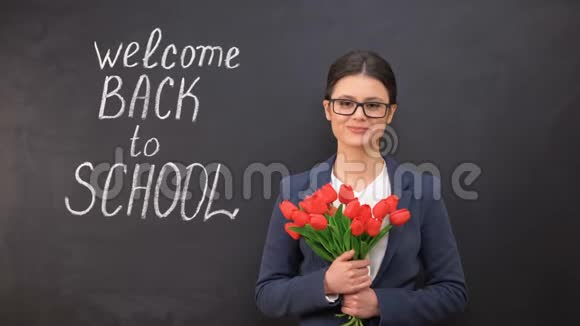 女老师微笑着捧着一束郁金香欢迎回到学校视频的预览图