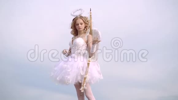 小丘比特用爱的箭瞄准某人天真的女孩有天使的翅膀站着弓箭视频的预览图