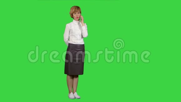 微笑的女人在绿色屏幕上打电话Chroma键视频的预览图