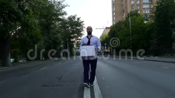 带着盒子的悲伤的人走在路中间视频的预览图