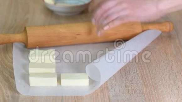 打黄油将黄油放在两张烤纸之间用擀面杖轻轻敲打成平的方形视频的预览图