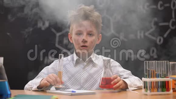震惊滑稽肮脏的小学生拿着化学管和烧瓶在他周围吸烟视频的预览图