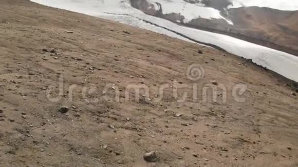 以厄尔布鲁斯山和一个大冰川为背景的火山岩俯瞰图视频的预览图