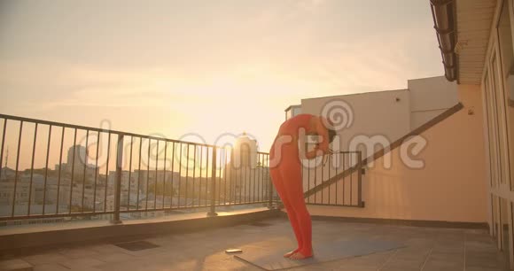 在美丽的城市景观中在屋顶上练习瑜伽的臀部女性特写镜头视频的预览图