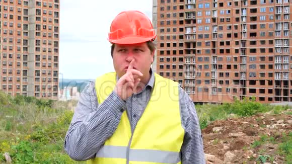 建筑工地上的建筑工人在要求保持沉默时用一个嘘声的手势把手指举到嘴唇上视频的预览图