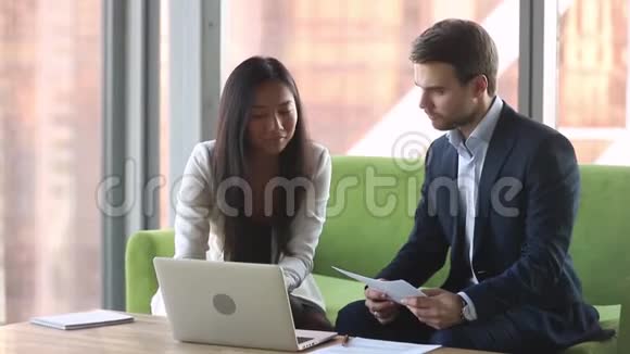 女性亚洲经理咨询白种人男性客户带笔记本电脑视频的预览图