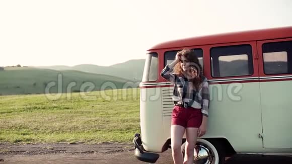 一个年轻的女孩站在一辆车上在乡间旅行视频的预览图