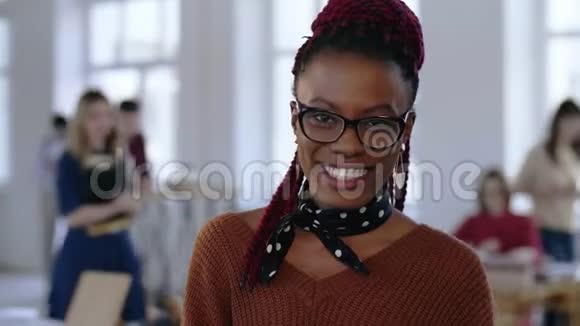 令人惊叹的特写照片年轻的非洲创意商业女性戴着眼镜洁白的牙齿在办公室微笑视频的预览图