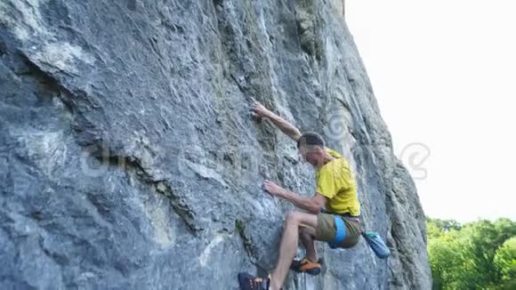 男子攀岩者的视频视角攀登悬崖上的运动路线搜索到达和抓握保持和裁剪视频的预览图
