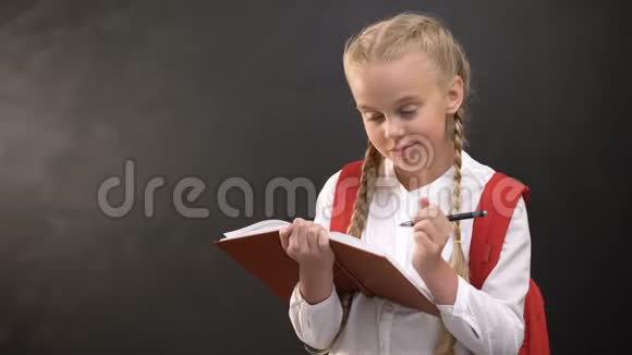 梦幻般的小女生在笔记本上写字靠着黑板做作业视频的预览图