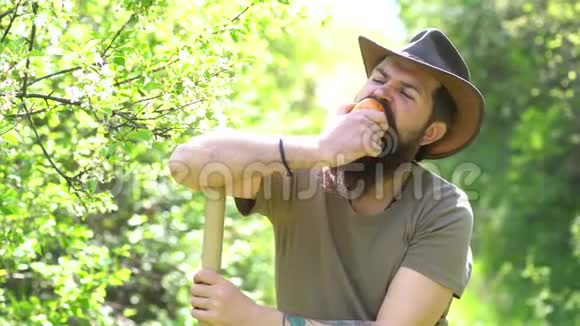 农家男孩在阳光明媚的日子在花园里吃蔬菜在农场里情绪化的搞笑胡子的潮人生态学概念视频的预览图