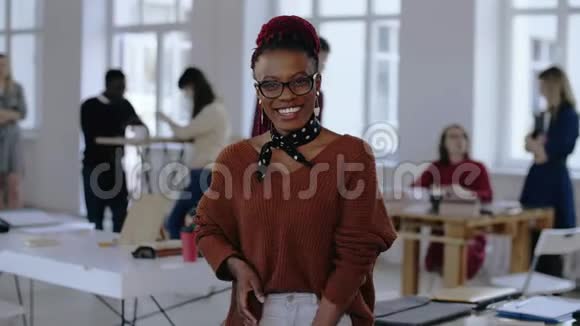 年轻的非洲企业家商业女性戴眼镜的创意工作者在现代光办公室微笑的肖像视频的预览图