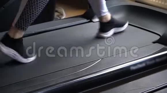 健身俱乐部的一个男人在跑步机上行走视频的预览图