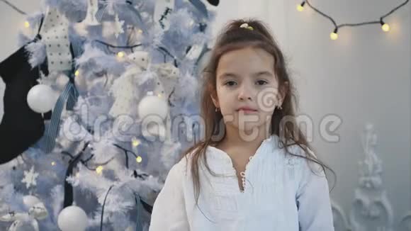 小女孩玩圣诞树雪花的特写视频把她的眼睛藏在后面视频的预览图